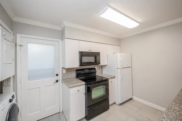 a kitchen with a refrigerator and a stove top oven