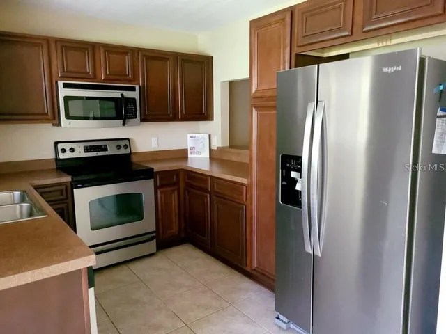 a kitchen with stainless steel appliances and refrigerator