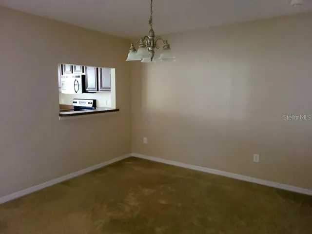 an empty room with windows and chandelier