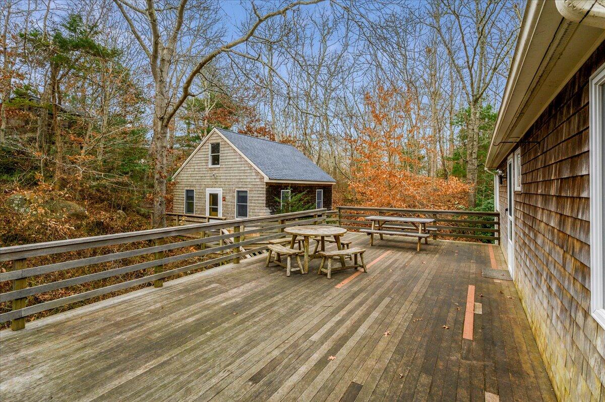 58 Oyster Pond Road Falmouth, MA 02540 - Photo 16 of 30 a view of a roof deck with table and chairs with wooden floor and fence