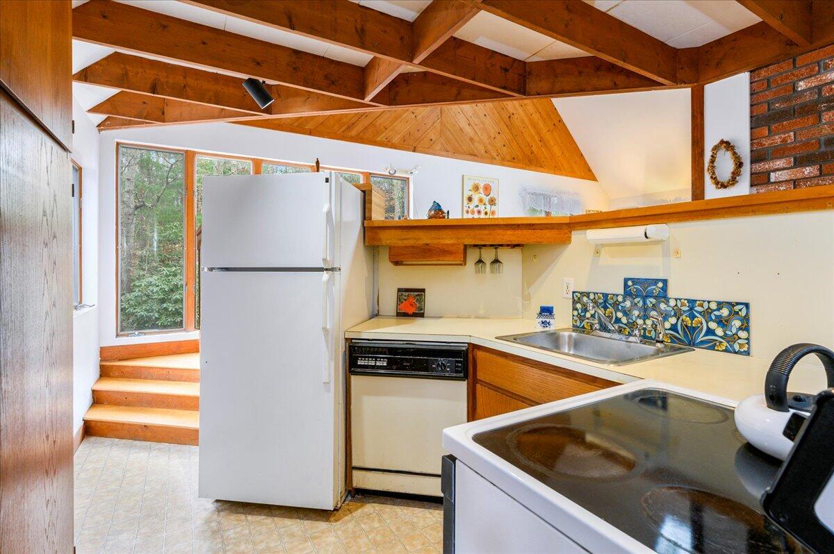 58 Oyster Pond Road Falmouth, MA 02540 - Photo 4 of 30 a kitchen with a sink a refrigerator and a stove top oven