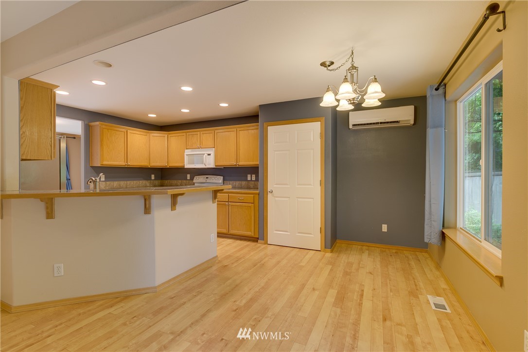 23034 12th Drive Southeast Bothell, WA 98021 - Photo 3 of 32 a view of a kitchen with kitchen island stainless steel appliances wooden floor cabinets and a window