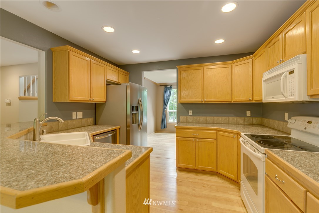 23034 12th Drive Southeast Bothell, WA 98021 - Photo 7 of 32 a kitchen with stainless steel appliances granite countertop a sink and cabinets