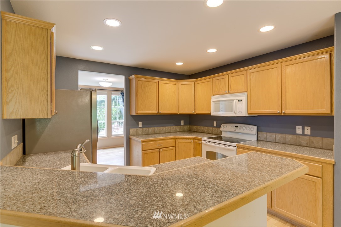 23034 12th Drive Southeast Bothell, WA 98021 - Photo 8 of 32 a kitchen with a stove a sink and a refrigerator
