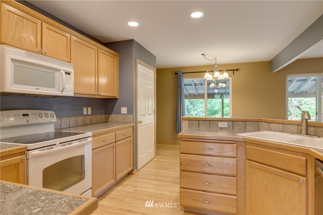 23034 12th Drive Southeast Bothell, WA 98021 - Photo 9 of 32 a kitchen with cabinets appliances a sink and a window