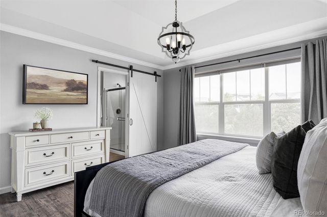 a bedroom with a bed a window and a chandelier