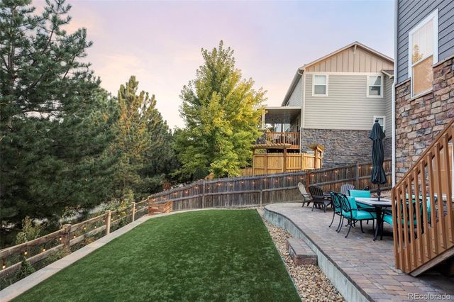 a view of a chair and table in backyard of the house