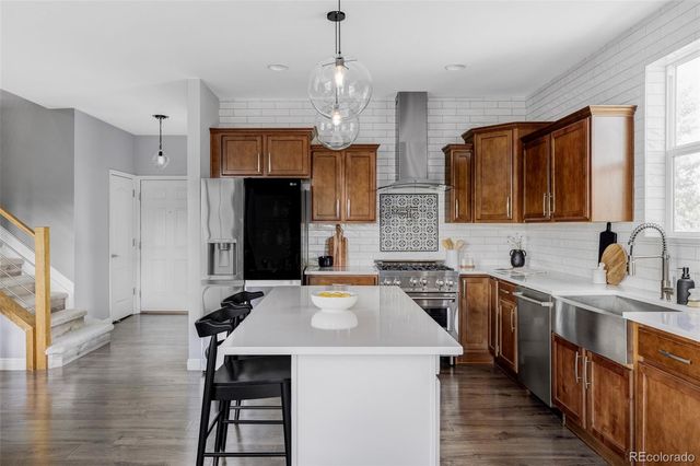 a kitchen with sink a refrigerator and wooden cabinets