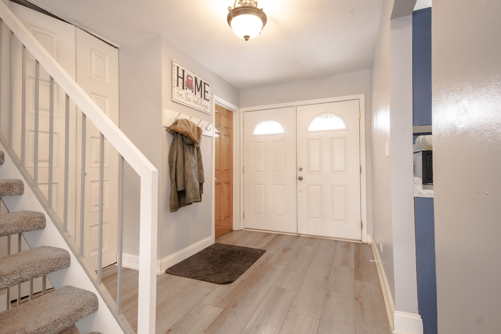 746 East Devon Avenue Roselle, IL 60172 - Photo 2 of 24 a view of a hallway with wooden floor and staircase