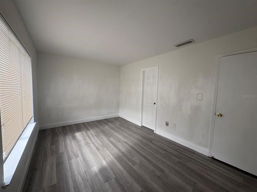 4033 Henley Road, Unit 1707 Orlando, FL 32839 - Photo 49 of 66 a view of an empty room with wooden floor and a window