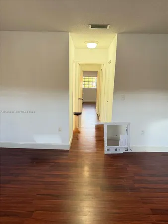 a view of a room with wooden floor and a window