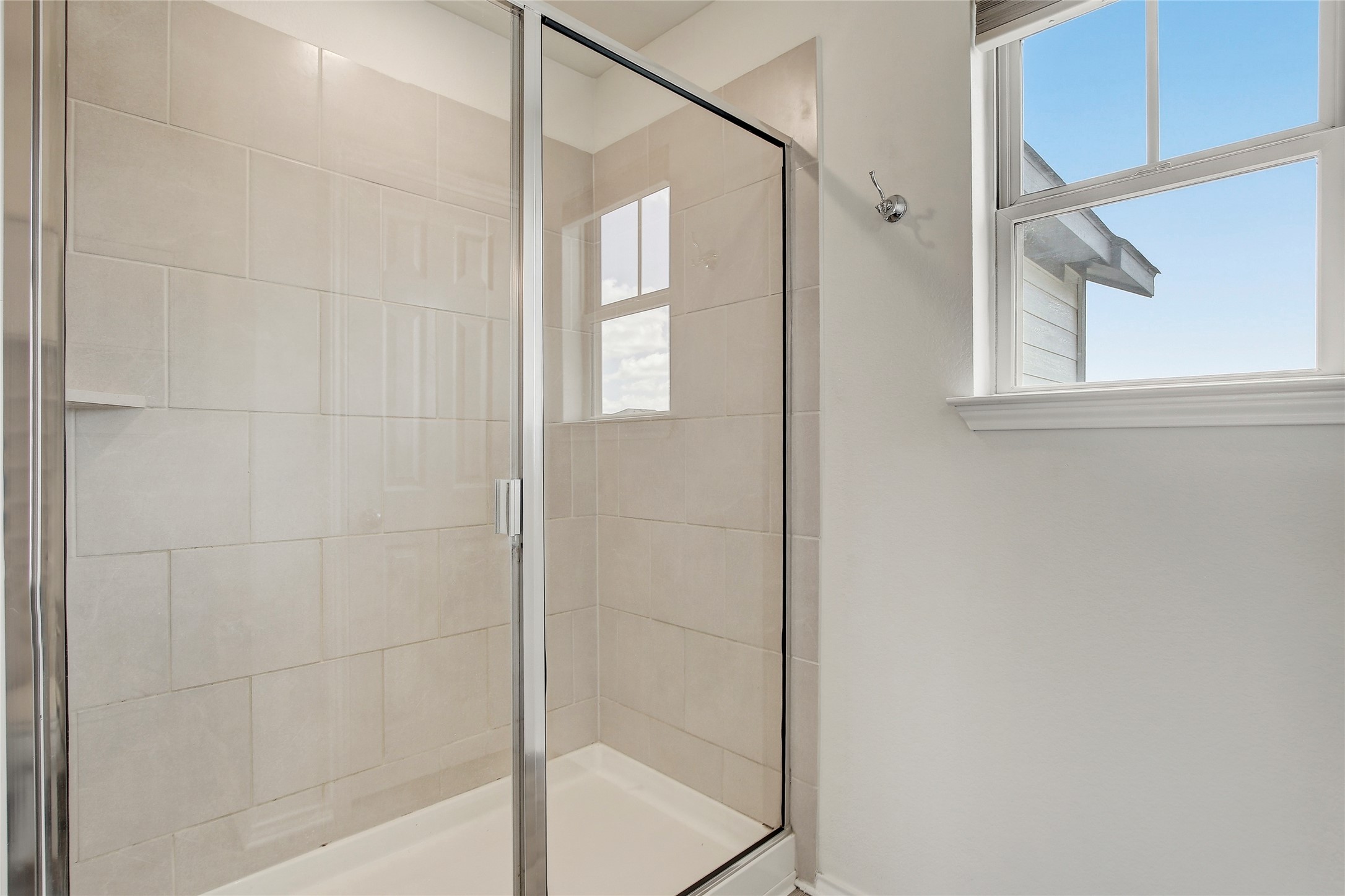 449 Stone Water Lane Jarrell, TX 76537 - Photo 13 of 18 Walk-in shower with clear glass enclosure and light-toned rectangular tile surround