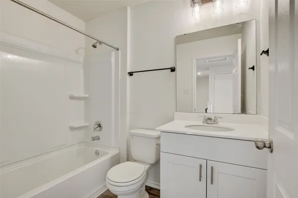 a bathroom with a sink toilet vanity and shower