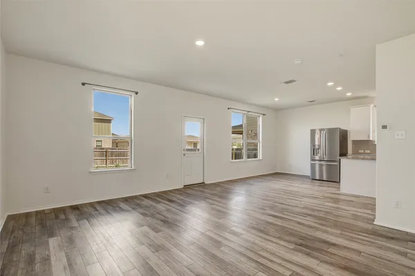 a view of empty room with wooden floor and window