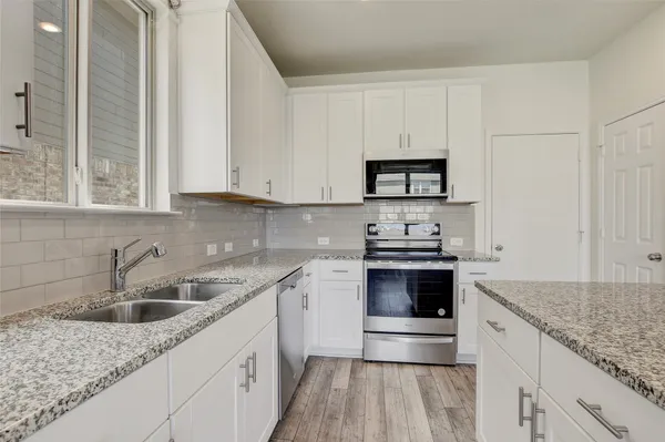 a kitchen with stainless steel appliances granite countertop a sink stove and cabinets