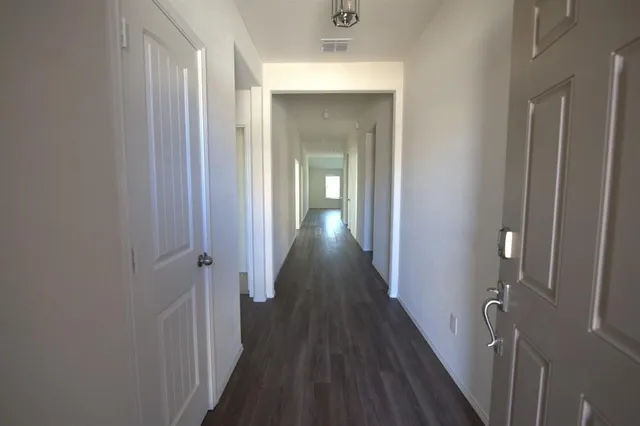 a view of a hallway with wooden floor