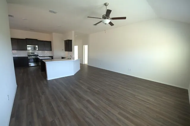 a view of a living room a kitchen and a wooden floor