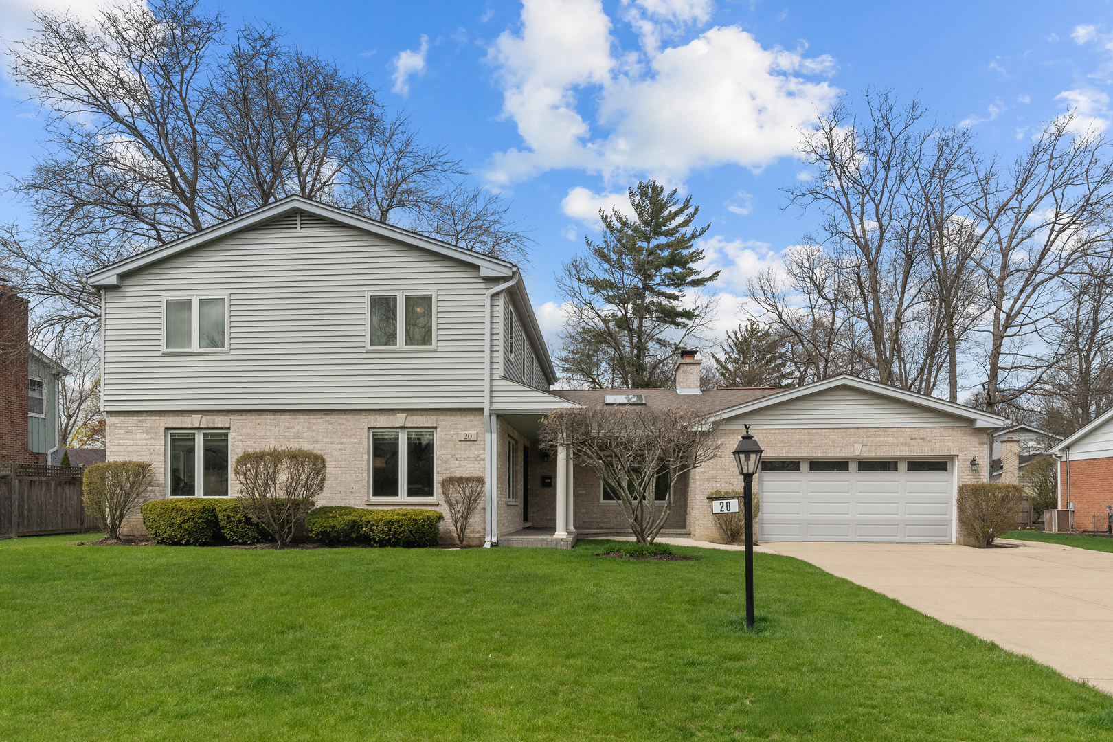 a front view of a house with a garden and trees