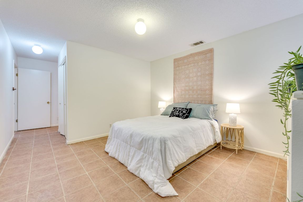 9226 Jollyville Road, Unit 132 Austin, TX 78759 - Photo 14 of 25 Bedroom with light tile patterned floors and a textured ceiling