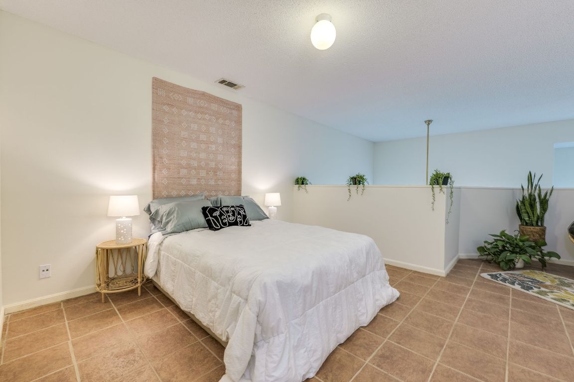 9226 Jollyville Road, Unit 132 Austin, TX 78759 - Photo 15 of 25 Bedroom featuring light tile patterned floors and baseboards