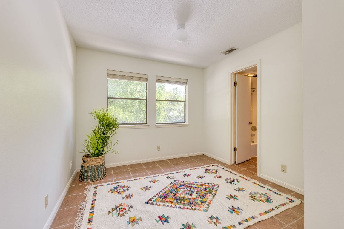 9226 Jollyville Road, Unit 132 Austin, TX 78759 - Photo 16 of 25 Empty room featuring light tile patterned floors and a textured ceiling