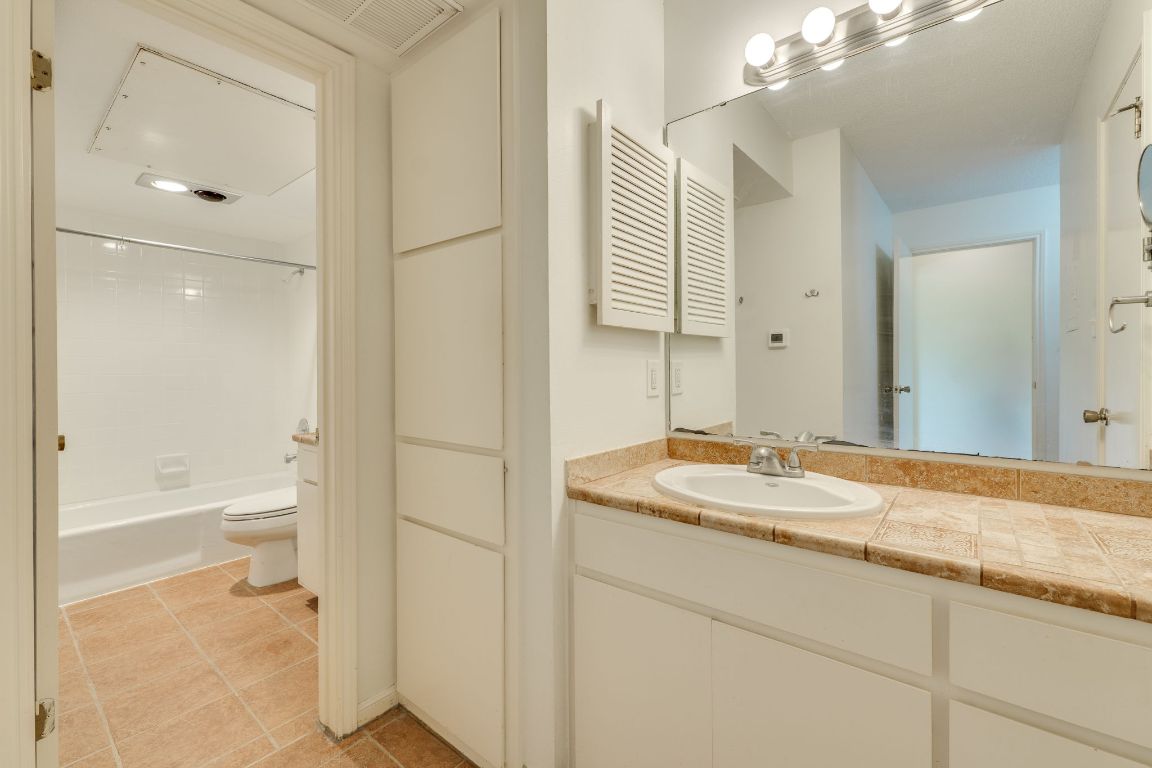9226 Jollyville Road, Unit 132 Austin, TX 78759 - Photo 19 of 25 Full bath featuring vanity, light tile patterned floors, and shower combination