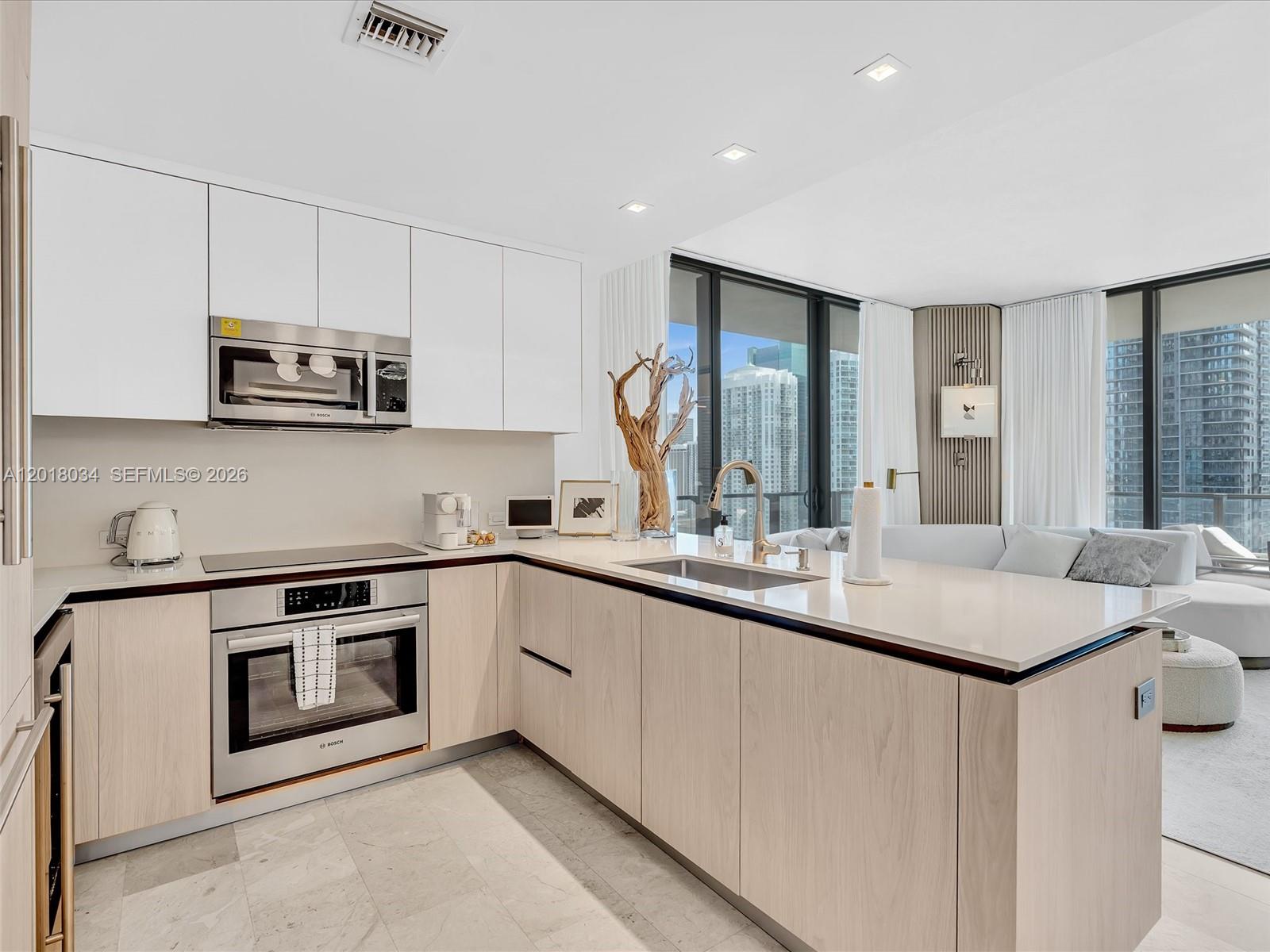 88 Southwest 7th Street, Unit 2011 Miami, FL 33130 - Photo 11 of 55 a kitchen with stainless steel appliances granite countertop a stove a sink and a microwave