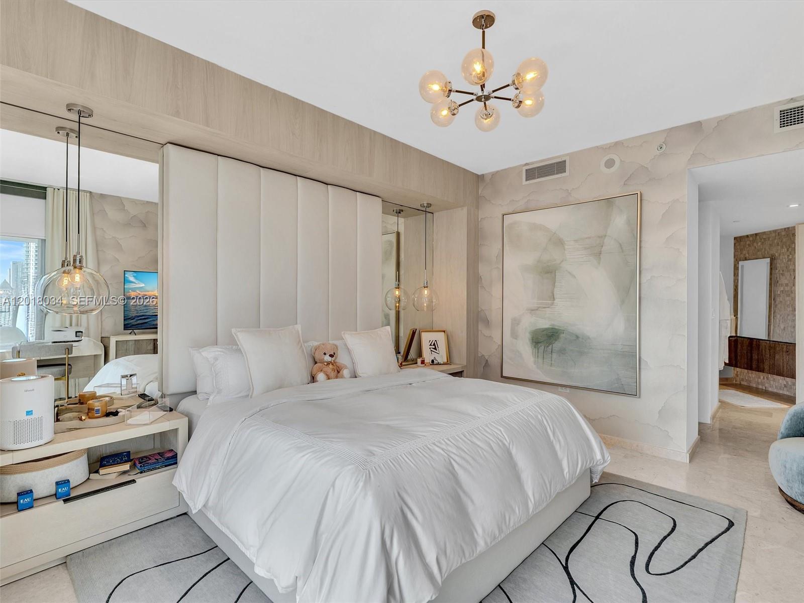88 Southwest 7th Street, Unit 2011 Miami, FL 33130 - Photo 35 of 55 a bedroom with a large bed and a chandelier