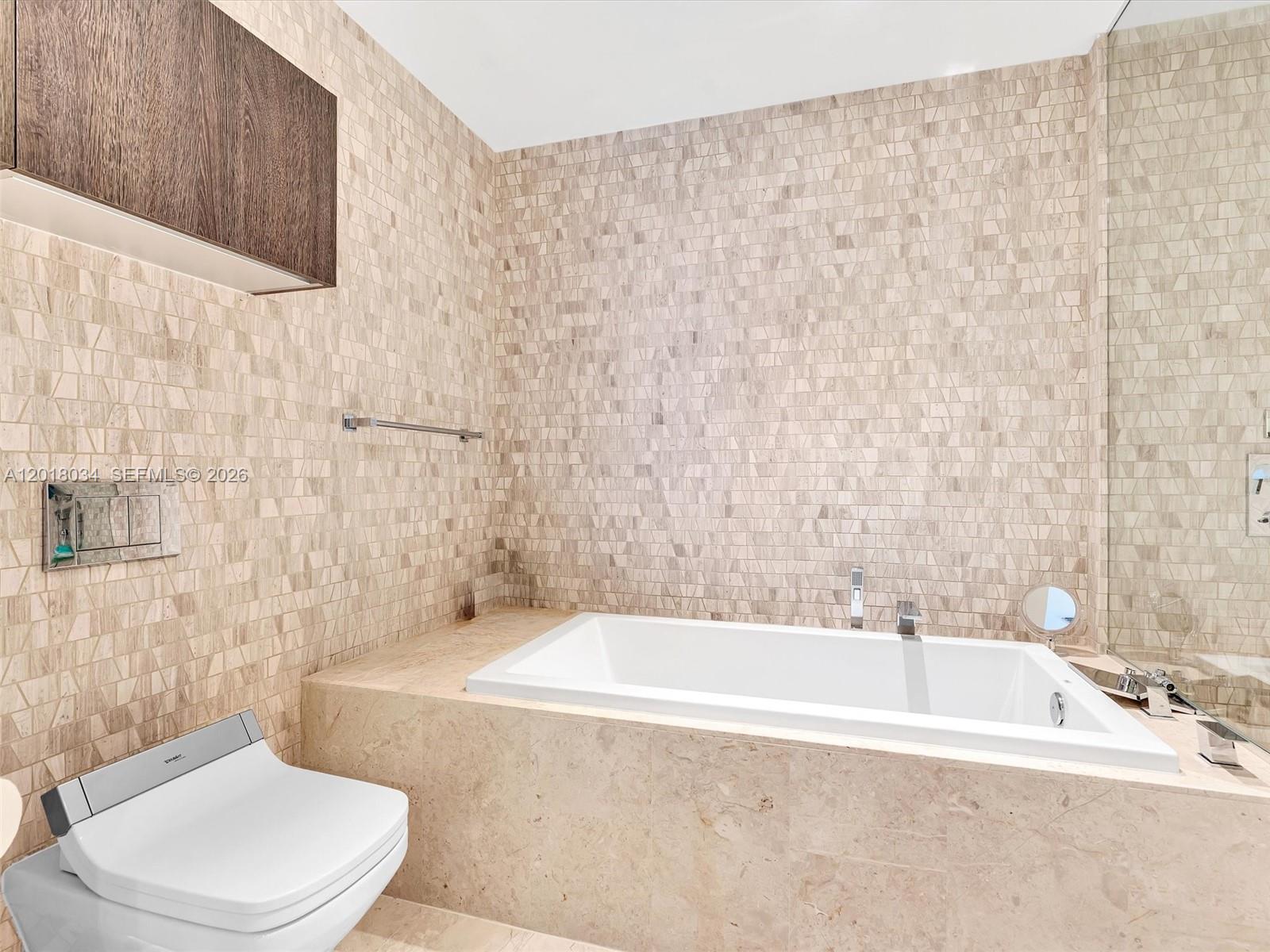 88 Southwest 7th Street, Unit 2011 Miami, FL 33130 - Photo 39 of 55 a bath tub sitting next to a white toilet