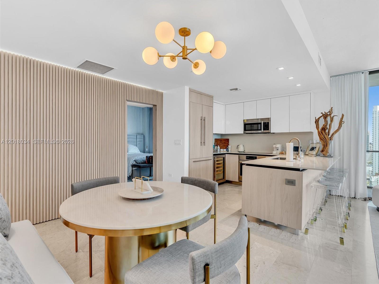 88 Southwest 7th Street, Unit 2011 Miami, FL 33130 - Photo 10 of 55 a kitchen with stainless steel appliances granite countertop a sink a stove a dining table and chairs
