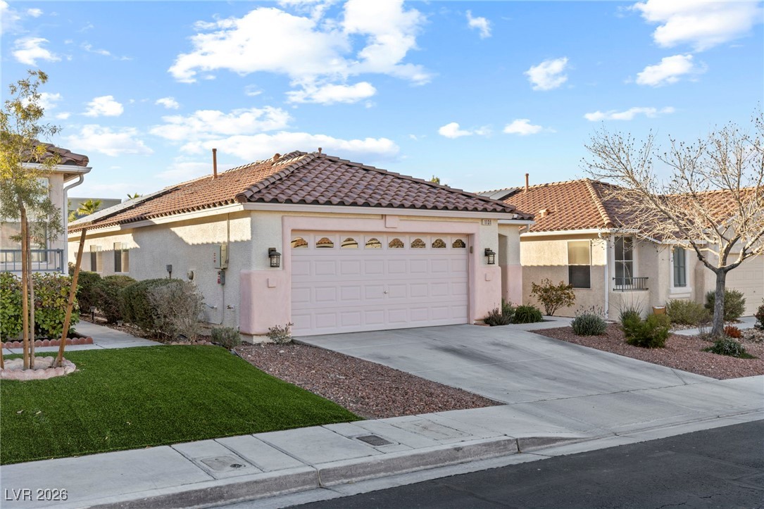 1131 Cathedral Ridge Street Henderson, NV 89052 - Photo 2 of 32 Long driveway with plenty of parking and coach lights on the garage for evening lighting