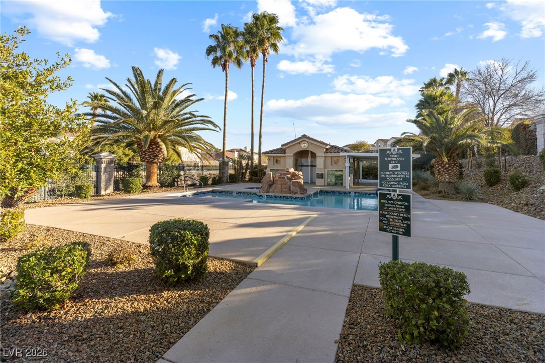 1131 Cathedral Ridge Street Henderson, NV 89052 - Photo 31 of 32 Community pool featuring a rock waterfall and resort-style palms