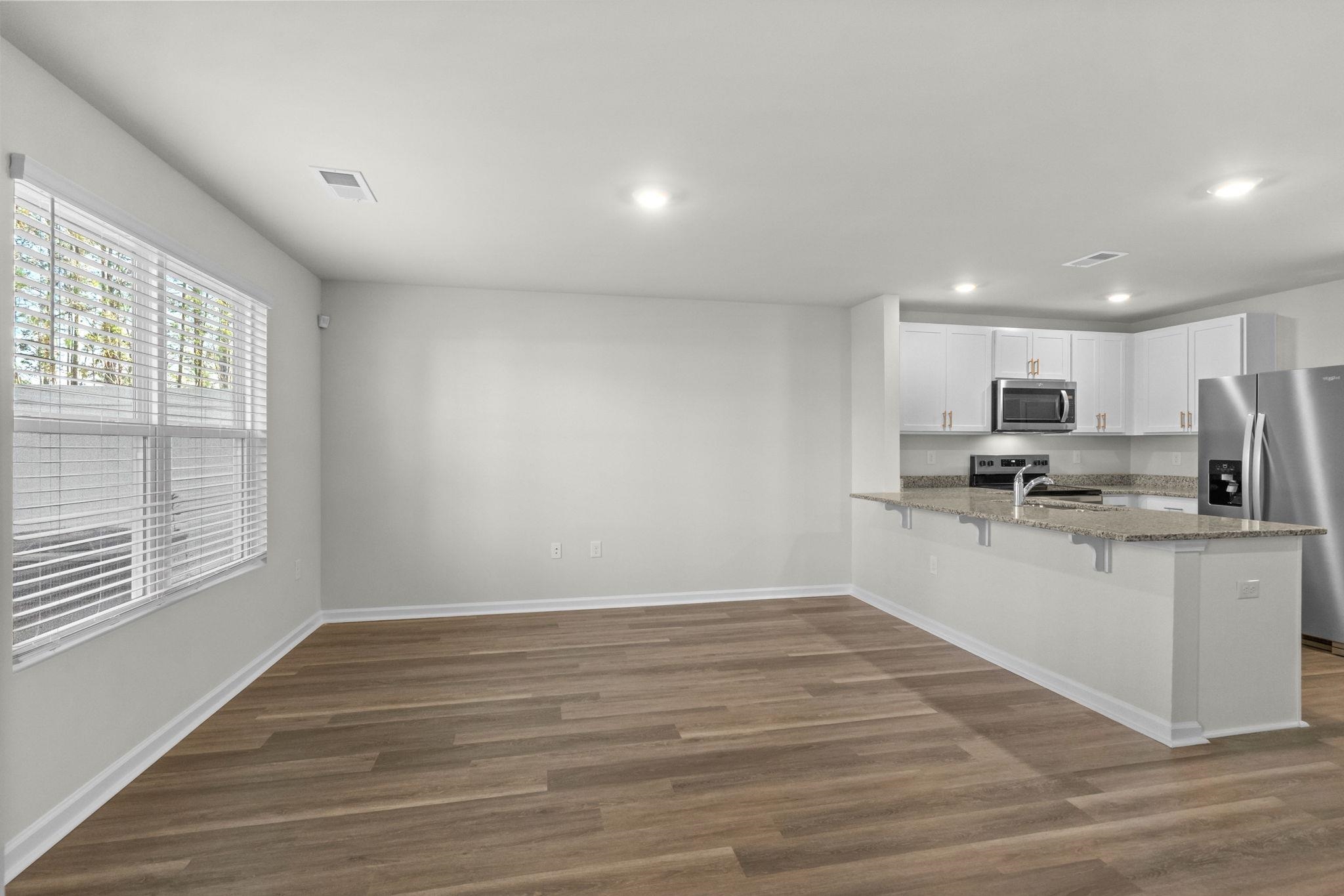 640 Golden Resin Road Conway, SC 29526 - Photo 4 of 38 Kitchen featuring white cabinetry, stainless steel appliances, a peninsula, light stone counters, and dark wood-type flooring