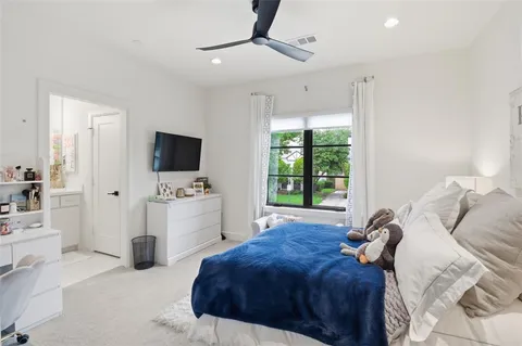 a bedroom with a bed and a flat tv screen on the dresser
