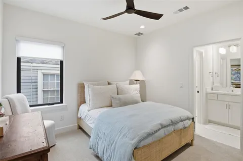 a bedroom with a large bed chandelier and a window