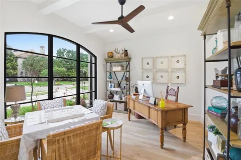 a living room with furniture a rug kitchen view and a large window