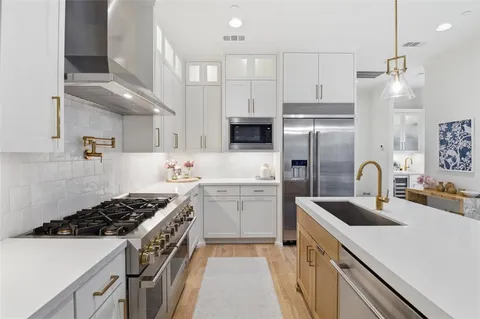 a kitchen with stainless steel appliances a sink stove and refrigerator