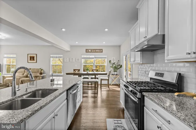 a kitchen with granite countertop a sink a counter top space stainless steel appliances and cabinets