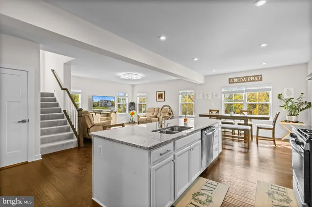 a open kitchen with stainless steel appliances granite countertop a lot of counter space and wooden floor