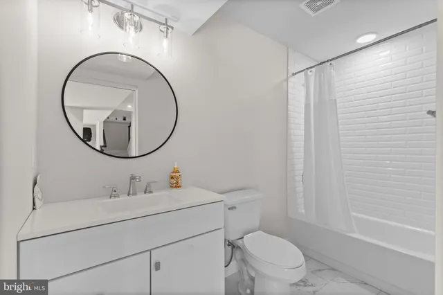 a living room with furniture ceiling fan and a large window