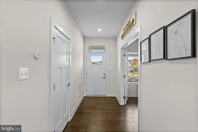 a view of hallway with stairs and wooden floor
