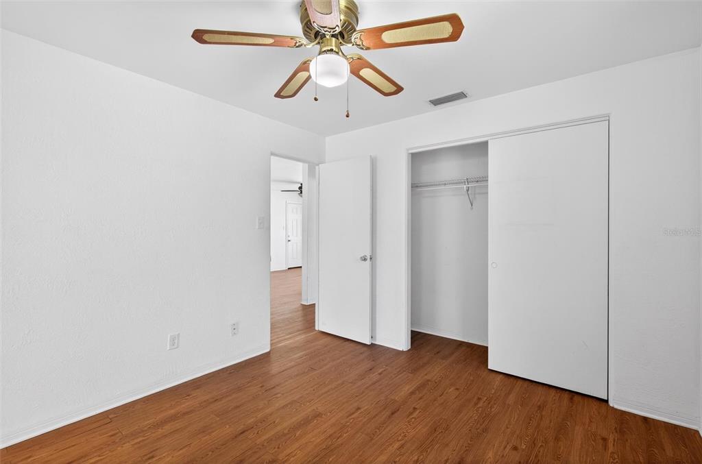 47 Carol Road Ormond Beach, FL 32176 - Photo 20 of 54 a view of a room with wooden floor and a ceiling fan