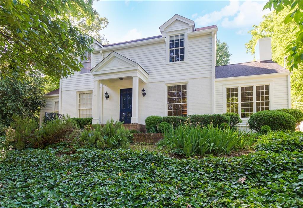 1899 Greystone Road Northwest Atlanta, GA 30318 - Photo 1 of 1 a view of a white house next to a yard with potted plants