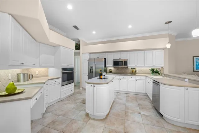 a kitchen with a sink a counter top space stainless steel appliances and cabinets