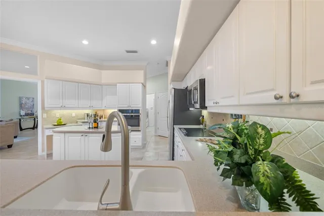 a living room with furniture a chandelier and a flat screen tv