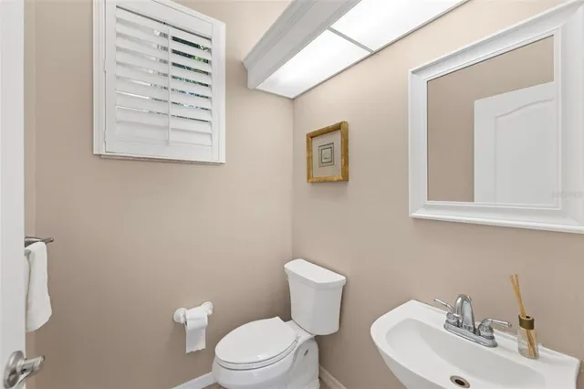 a bathroom with a granite countertop sink toilet and a mirror