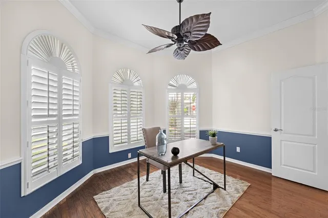a workspace with a window and a chandelier fan