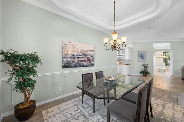 a living room with dining table and a chandelier