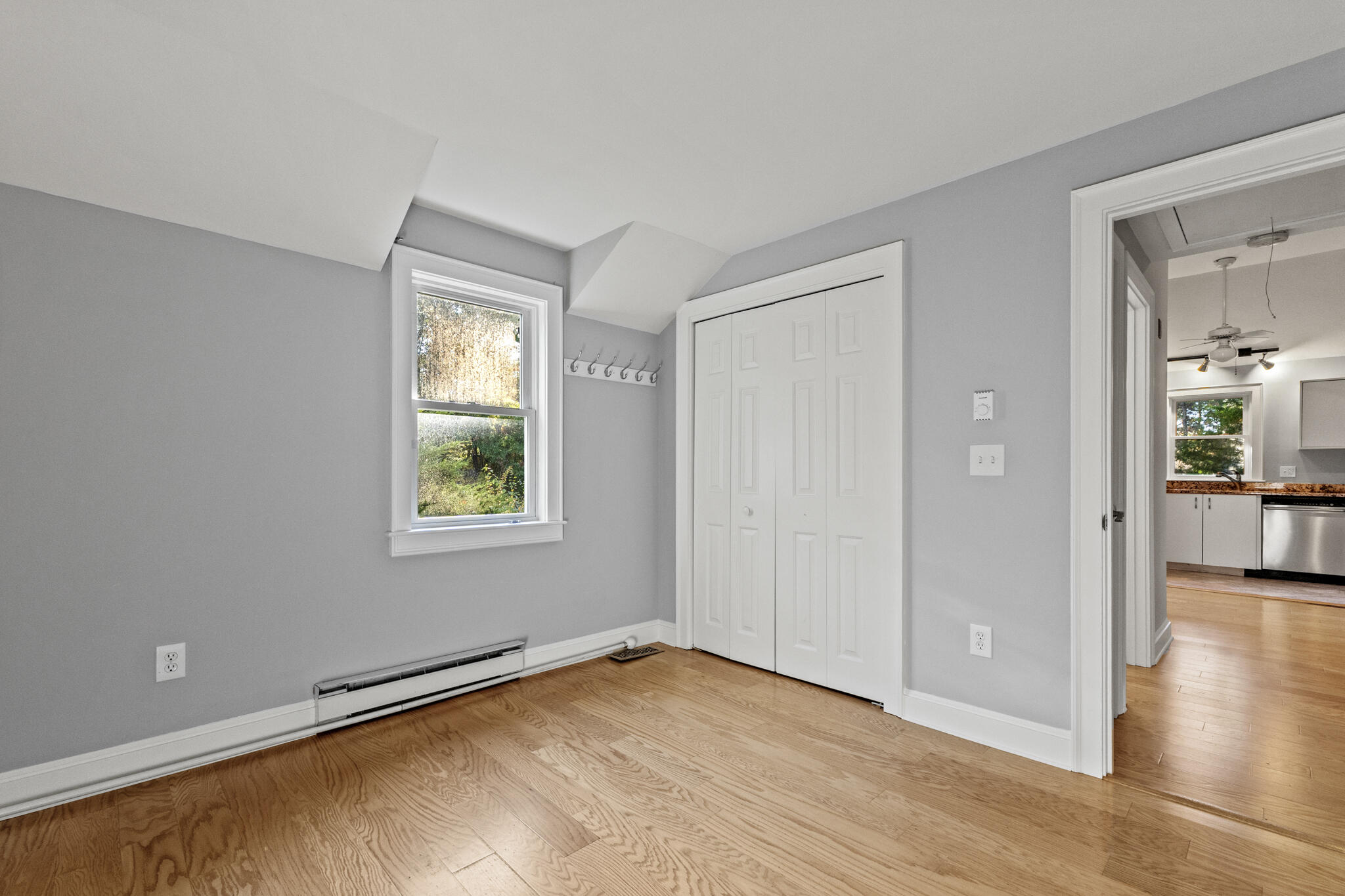 24 Ryan's Way, Unit 6 Mashpee, MA 02649 - Photo 15 of 23 a view of an empty room with wooden floor and a window