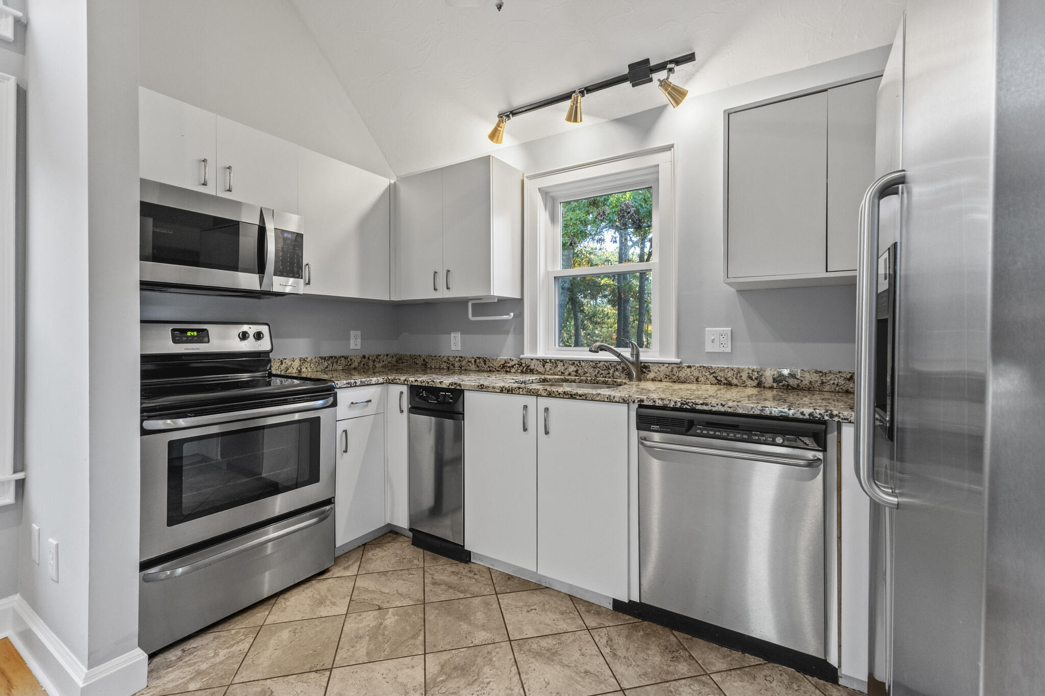 24 Ryan's Way, Unit 6 Mashpee, MA 02649 - Photo 9 of 23 a kitchen with stainless steel appliances granite countertop a stove a refrigerator and a microwave
